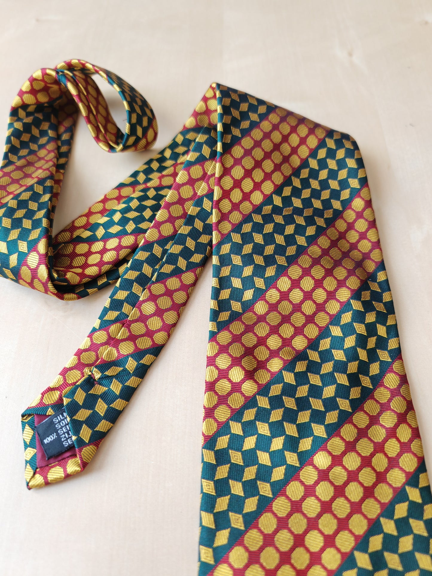 Cravatta geometrica rossa verde e oro